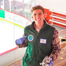 Evan Sims with badge earned from helping with Green Game
